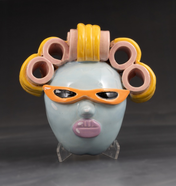 Pink lips, blue skin, orange glasses and hair in curlers by Jimena de Dios
