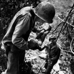 <p><b>W. Eugene Smith</b>, <i>U.S. Marine holding a wounded and dying baby found in the mountains at the Battle of Saipan Island during the Pacific Campaign. World War II. June, 1944.</i></p>