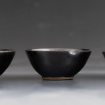 Three black bowls by Nina Atkinson